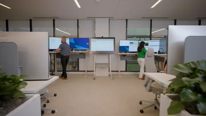 Wide shot of SLB Performance Live center with engineers at dual-screen monitoring workstations by Motion Giraffx