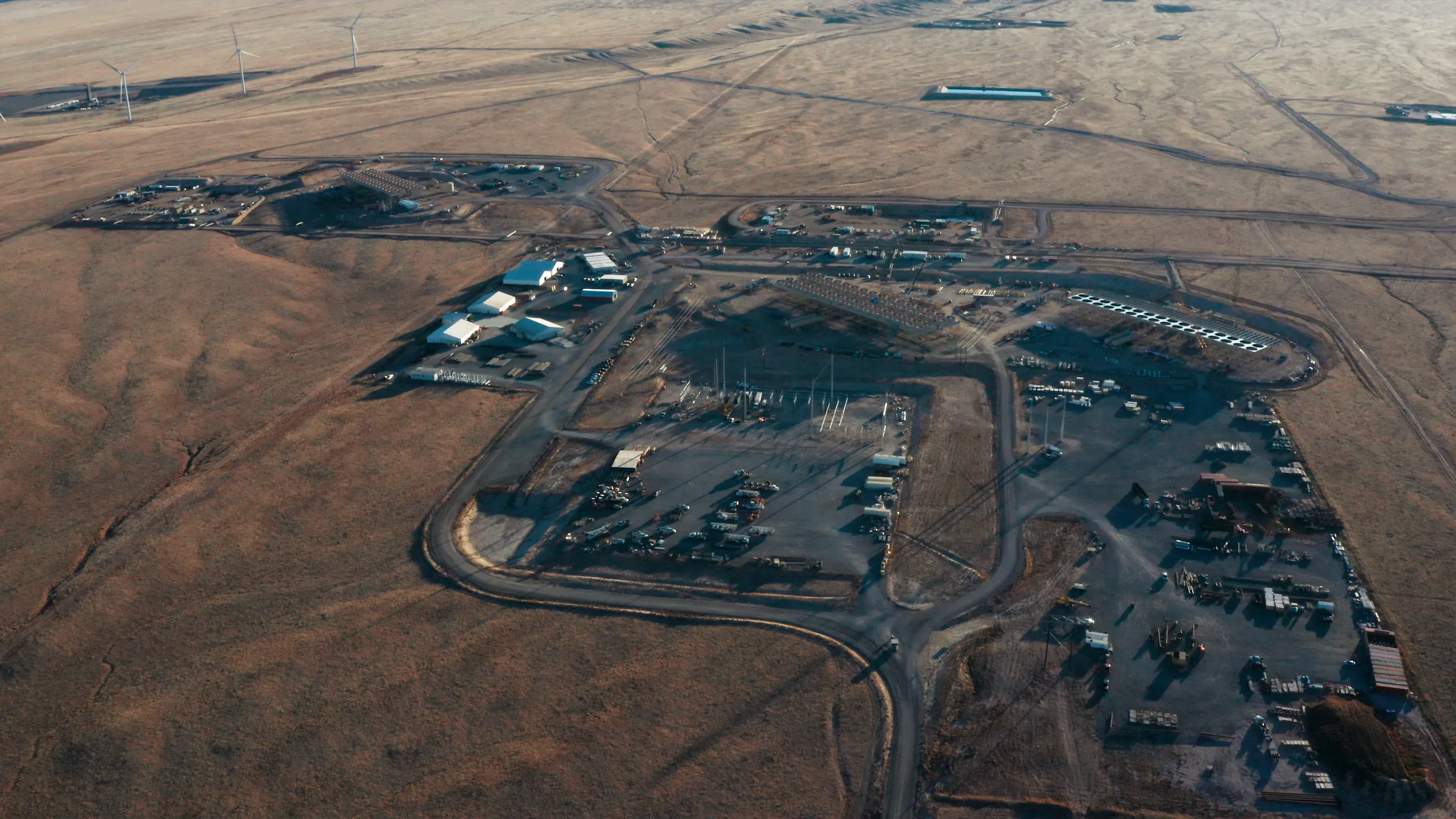 High-altitude aerial of the full Fervo Cape Station footprint with the Sevier Desert horizon stretching beyond by Motion Giraffx.
