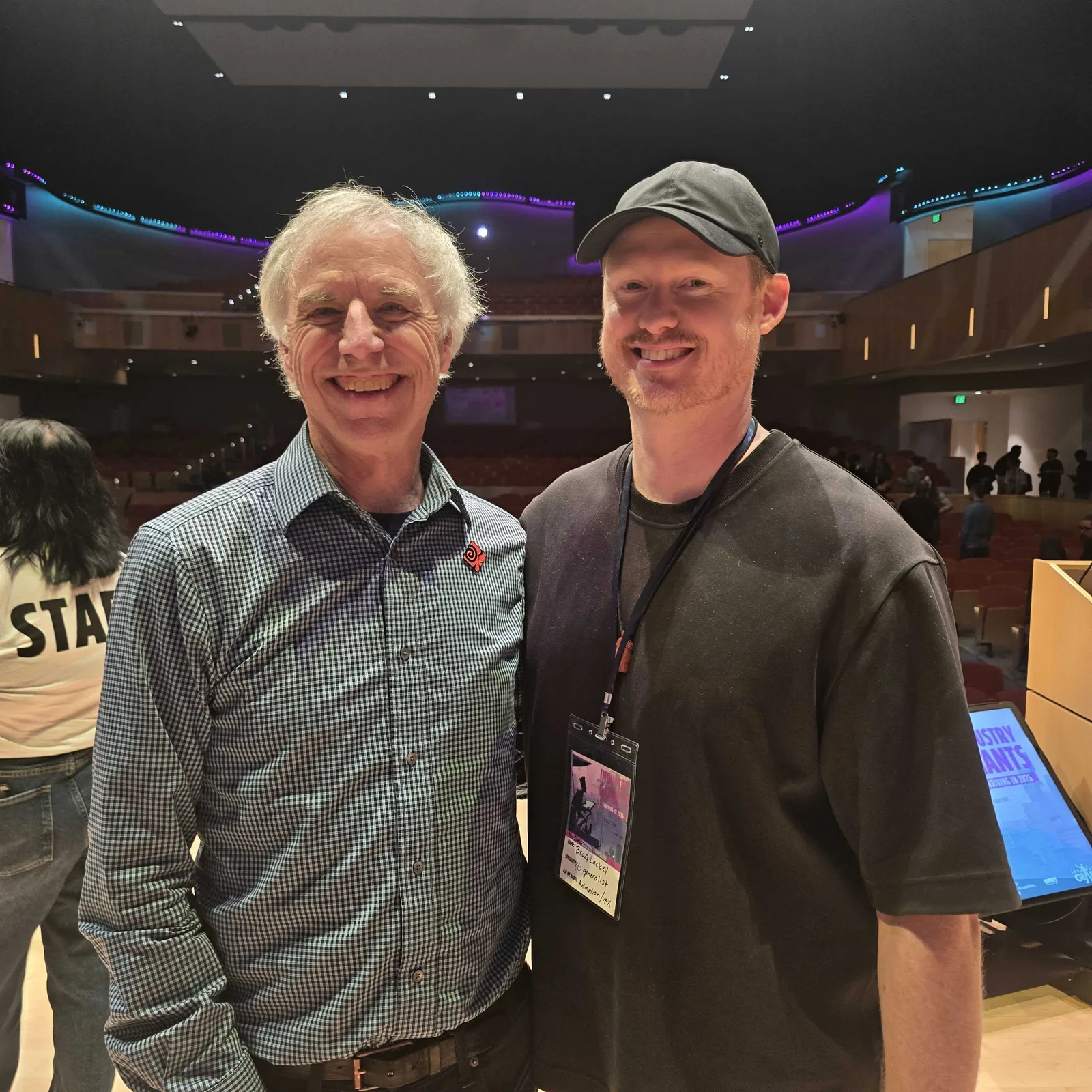 Kim Davidson (left) and Brad Lackey of Motion Giraffx, in a black cap (right), in the auditorium at Industry Giants 2026