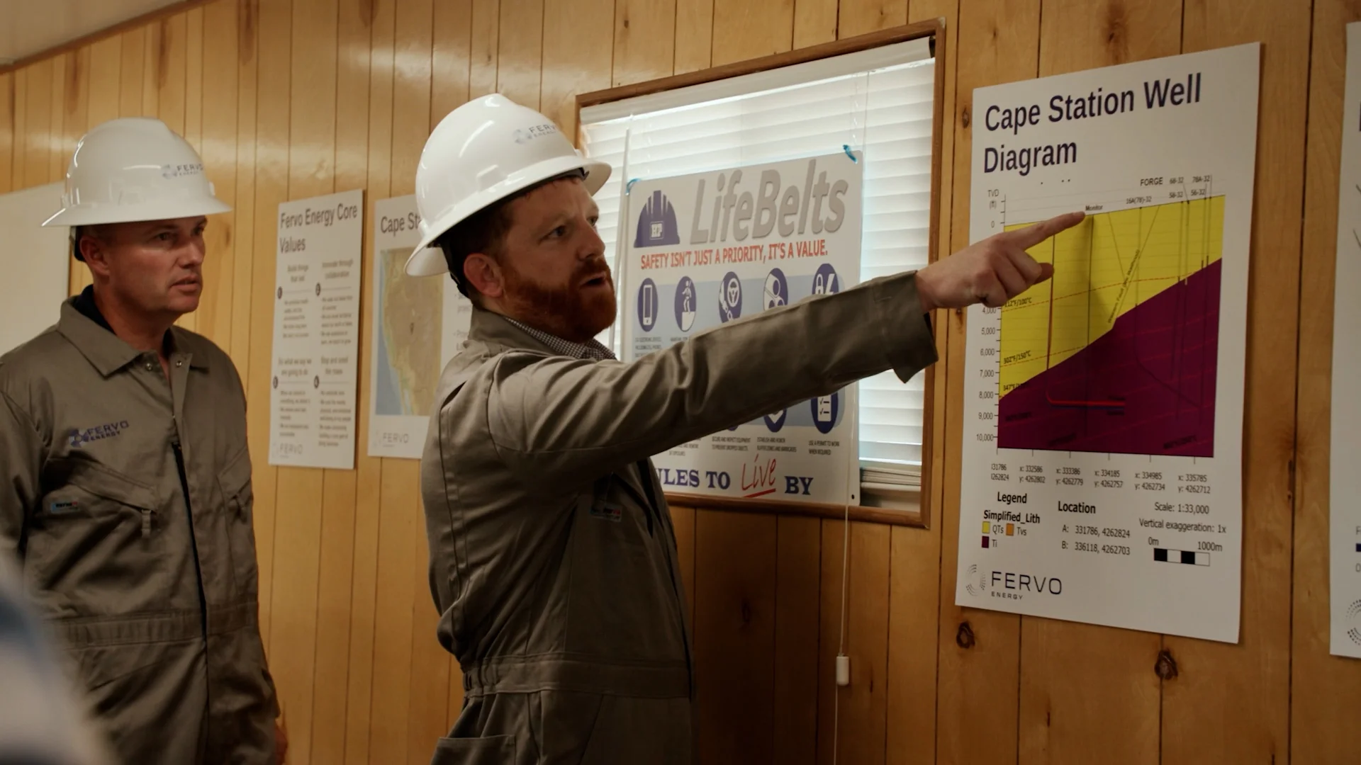 Two Fervo engineers in white hard hats reviewing the Cape Station well diagram in a field office, captured by Motion Giraffx.